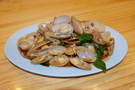 Close up Clams fried chilli basil leaves on the white dish , Homemade Thai food (Top View)の写真素材