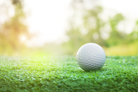 Golf balls on green lawns in beautiful golf courses with sun rise background.Important equipment to play golf.Sports that people around the world play during the holidays for health.の写真素材