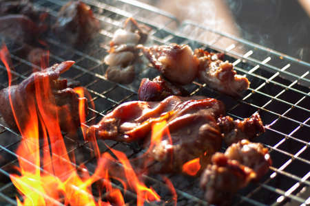 Steak on the grill with flames and smoke. Outdoor cooking using a wood charcoal stove. Popular BBQ...