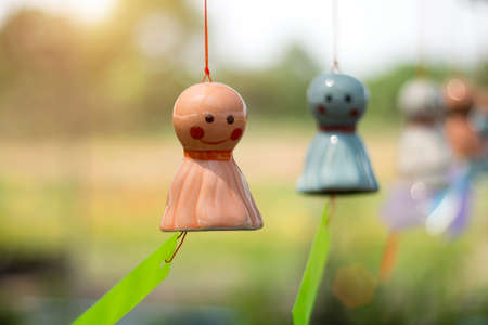 The smiling face doll made of ceramic is swaying in the wind. Asian-themed home and garden...