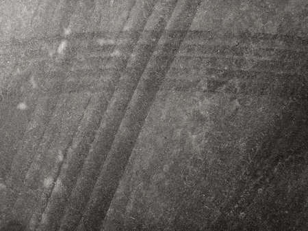 Close up black tire marks on cement floor. Abstract concrete texture in vintage style. Dark...