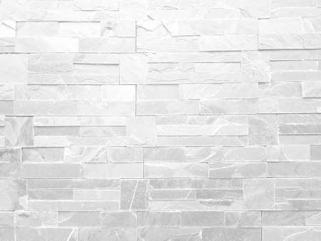 Rough white stone wall background in vintage style for graphic design or wallpaper. Pattern of soft nature floor in retro concept. Gray abstract texture detail in construction or exterior decoration.の写真素材