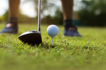 Golf clubs and golf balls on a green lawn in a beautiful golf course with morning sunshine.Ready for golf in the first short.Sports that people around the world play during the holidays for health.の写真素材