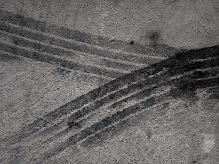 Close up black tire marks on cement floor. Abstract concrete texture in vintage style. Dark...