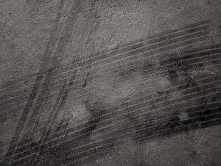 Close up black tire marks on cement floor. Abstract concrete texture in vintage style. Dark...