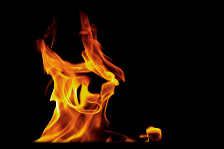 Flames isolated on black background for graphic design or wallpaper. Close up red and yellow, heat...