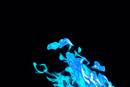 Close up blue flames on black background for graphic design or wallpaper. Thermal energy from gas...