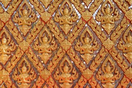 Golden Thai style pattern design at the wall of temple.の写真素材