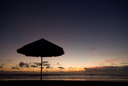 beautiful sunset on the beach with parasolの写真素材
