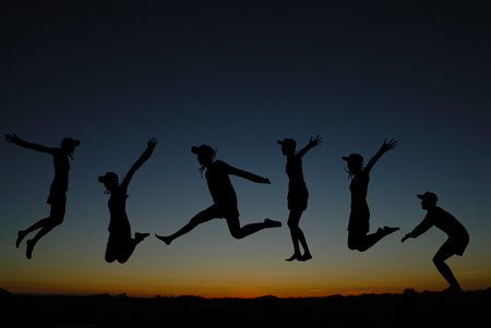 silhouette of  people jumping at sunriseの写真素材