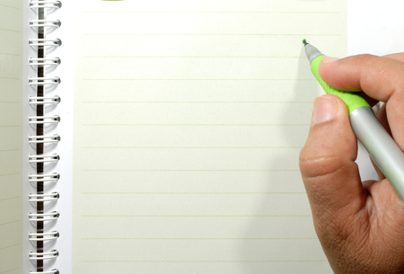 hand holding a pen writing on the notebookの写真素材