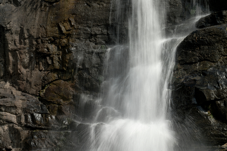 Waterfall close up. water cascade on black stones