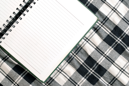 blank note book  open on fabric texture