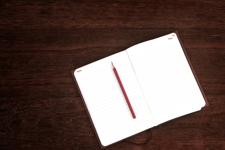 notebook with pencil on wooden tableの写真素材