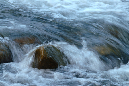 Stream water flowing past stones, Long exposure.の写真素材