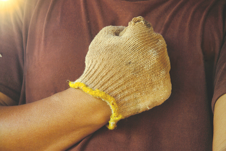Hand of worker with old dirty fabric glove.の写真素材