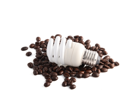 Energy saving light bulb on stack of coffee beans. Isolated on white background.の写真素材