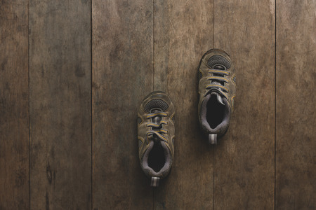 Brown running shoes laid on wooden floor.の写真素材