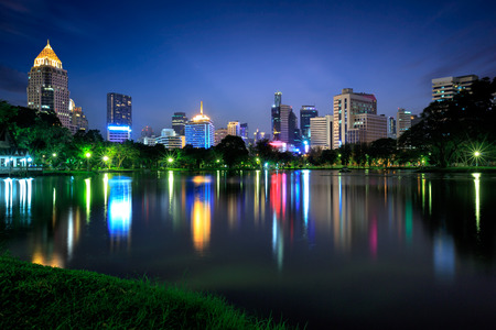 Business district cityscape from a park with twilight time from lumpini park, Bangkok Thailand