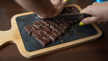 A broken bar of milk chocolate on the plateの写真素材