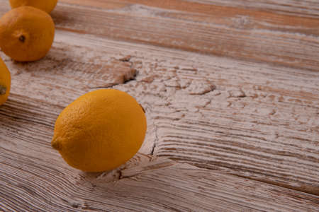 Freshly cut half and whole lemons on rustic boards.