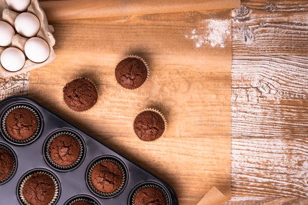Chocolate muffins with crispy top on Wood Table Background, Rustic Still Life Style Concept and Idea of Sweet Food Bakery Dessert Time, To Eat with Coffee or Hot Drink in the Morning or Tea Time.の写真素材