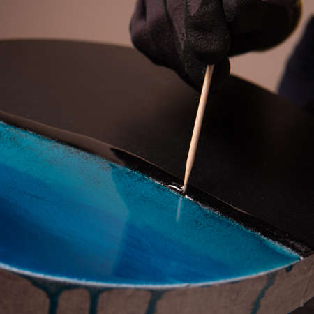 Epoxy resin. The creative hobby process of creating an artists painting of a liquid resin imitation of the sea on a slate stone boardの写真素材