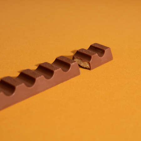chocolate bar with milk filling on orange background