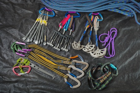 Equipment for mountaineering and rock climbing on a black waterproof fabric.の写真素材