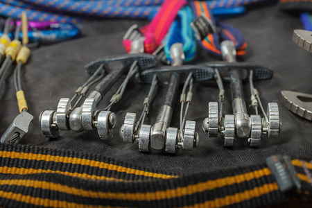 Equipment for mountaineering and rock climbing on a black waterproof fabric.の写真素材