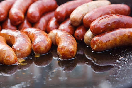 Street food. Sausages are fried in a large frying panの写真素材