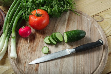 Vegetarian food. Fresh green vegetables on a wooden table and board for cutting.の写真素材