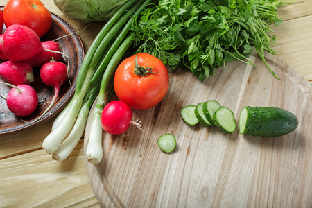 Vegetarian food. Fresh green vegetables on a wooden table and board for cutting.の写真素材