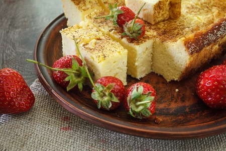Cheesecake with strawberries. On a wooden table strawberries and linen napkin