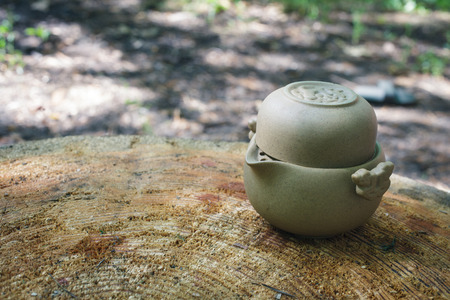 Tea set of Yixing clay. In the shade of the trees on a large stump.の写真素材