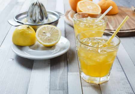 The cooled drink with fresh lemon and orange. On the table two glasses with a drink and fresh fruitの写真素材