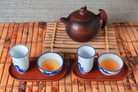 tea set on a table with a bamboo mat. porcelain cupsの写真素材