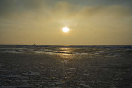 Frozen shore of the Kiev Sea at sunset. colorful cloud landscape. Sun reflections on ice. Nature, climate change. panoramic viewの写真素材