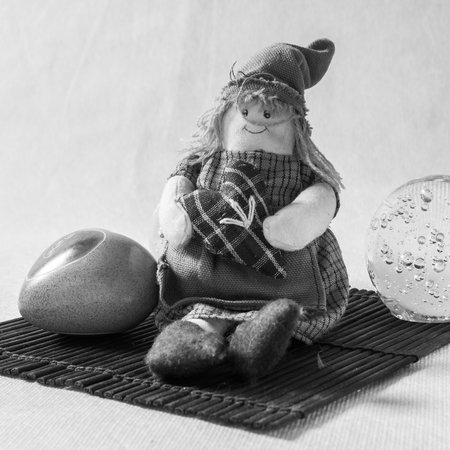 Decorative elements on a bamboo table. Rag doll and ceramic heart