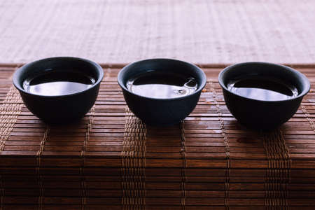 tea set on a table with a bamboo mat. porcelain cupsの写真素材
