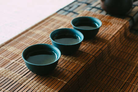 tea set on a table with a bamboo mat. porcelain cupsの写真素材