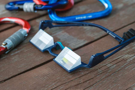Climbing equipment and prism goggles for belaying on a wooden backgroundの写真素材