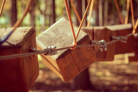 The bridges, ropes and ladders of the Adventure Park are designed for beginners among the tall trees. Adventure climbing in a high rope course. Rope track in the city parkの写真素材