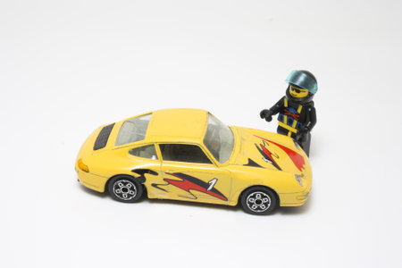 Sports car driver next to his yellow Porche car - toysの写真素材
