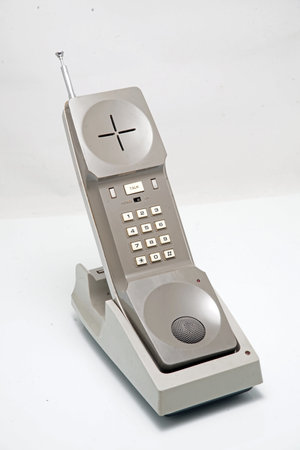 An old vintage wireless phone with a built antenna - on the charging - on white backgroundの写真素材