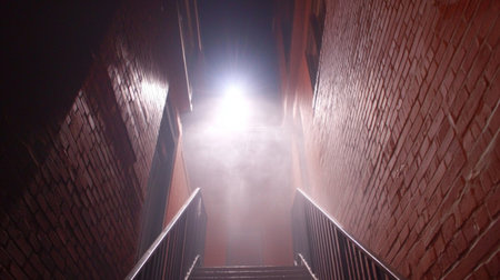 A captivating scene of an alleyway featuring a bright light source amidst mist, creating a mysterious and atmospheric feel perfect for urban-themed projects.の素材