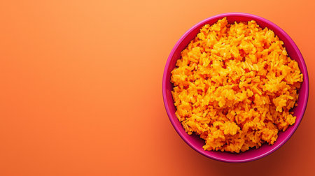 A vibrant bowl of bright orange rice fills the frame, showcasing its texture against a bold background, perfect for food-related projects and culinary inspiration.の素材