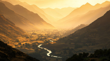A breathtaking view of a mountain valley at sunrise, showcasing a winding river surrounded by lush fields and majestic peaks bathed in golden light.の素材
