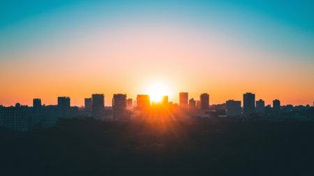 Captivating sunset view over a city skyline, showcasing silhouettes of buildings against a vibrant orange and blue sky, creating a serene urban landscape.の素材