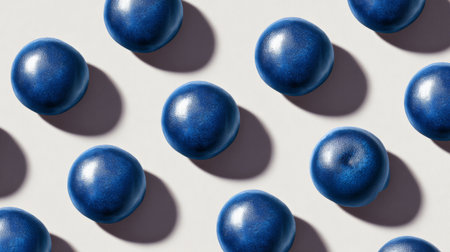 A captivating arrangement of vibrant blue fruit orbs, each displaying a unique texture and shine, perfectly aligned to create a visually striking pattern on a soft surface.の素材